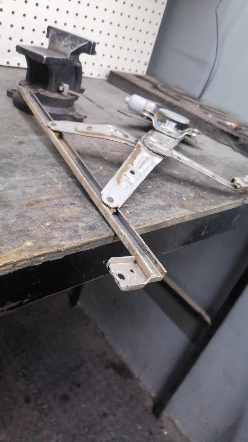 Elevador de tijera del Honda Civic desmontado sobre el banco, como llegó al taller